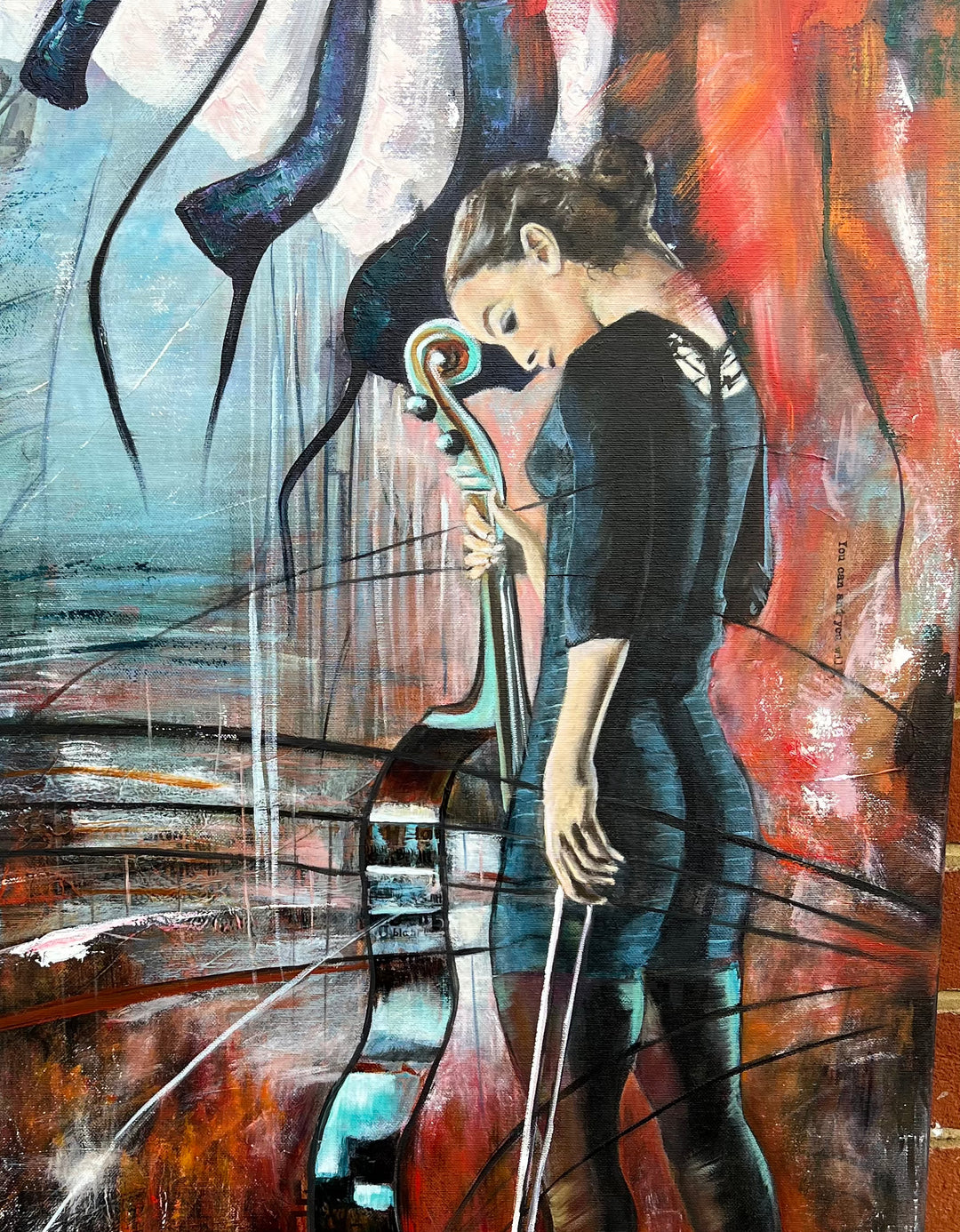 Close-up detail of 'The Sound of Strength' by Tash Bardot, highlighting the woman's peaceful, grounded expression as she rests her hand on the neck of the cello.